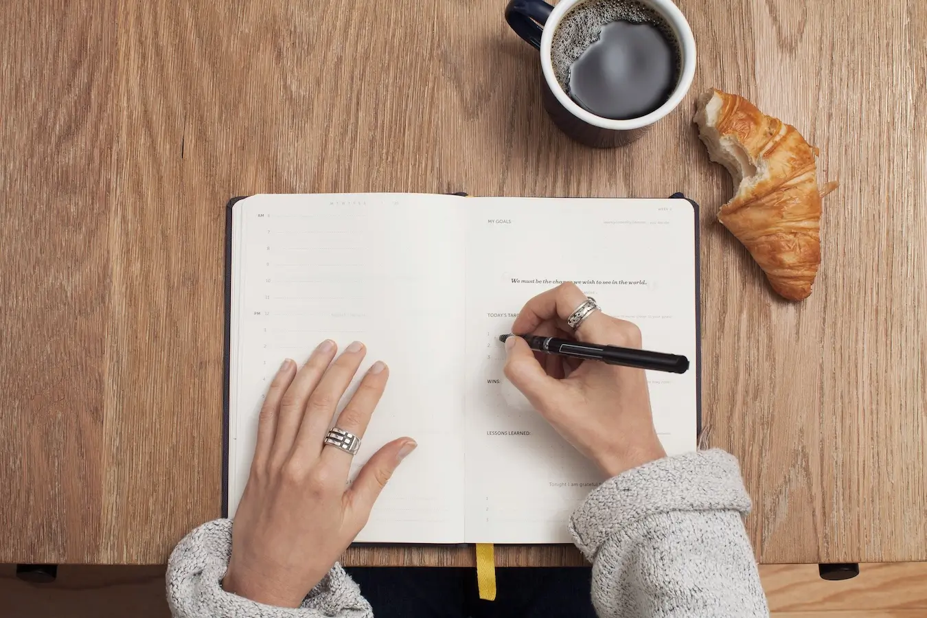 schrijven in een note book met koffie en croissant